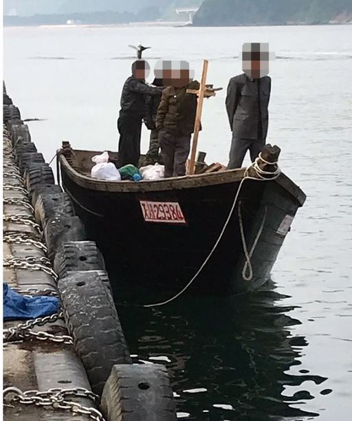 강원 삼척시 정라동 삼척항에 자력으로 입항한 북한 주민 4명이 목선에 서 있는 상태로 삼척항 주변을 살펴보고 있다.